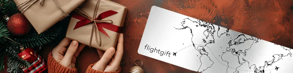 Hands holding Gifts Next to Airline Ticket with World Map - Christmas Themed